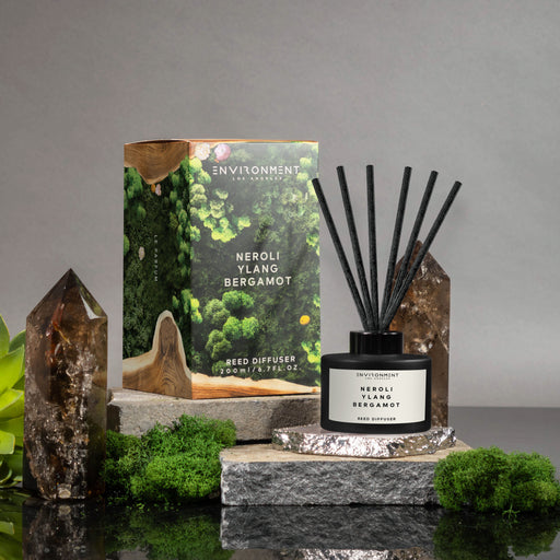 Reed diffuser with packaging on a gray background
